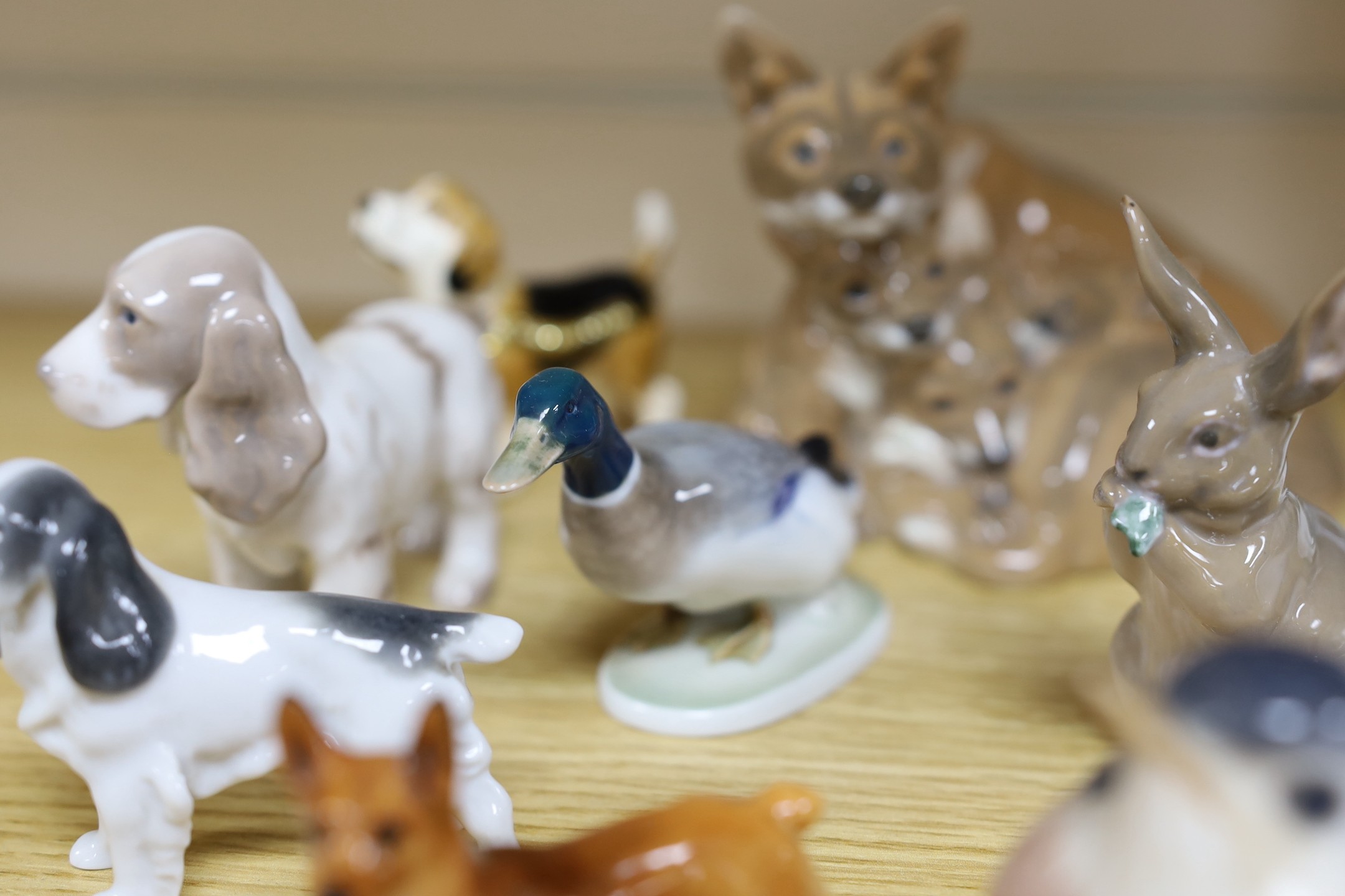 Sixteen various Royal Copenhagen porcelain birds and animals, including a faun playing pipes, a fox group and a metal foxhound, faun 21 cms high